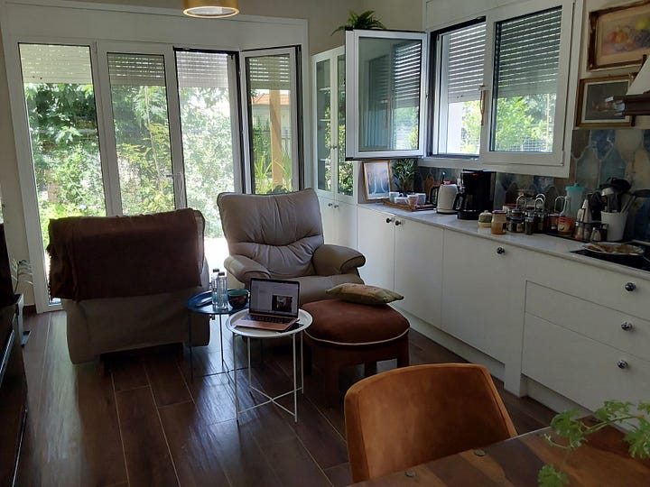 Kitchen with wooden table and armchairs in the centre of the room.