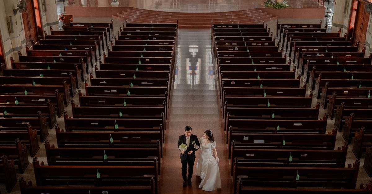 Photo: Huy Nguyễn / Pexels A newlywed couple walking down the aisle in an elegant church setting, captured from above.