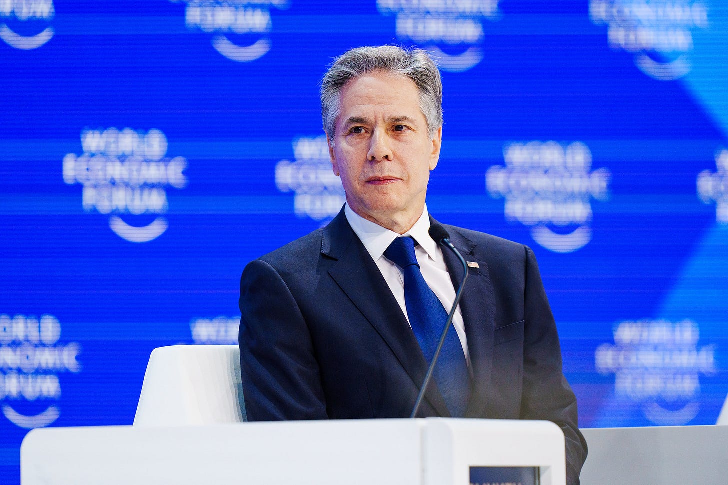 US Secretary of State Antony Blinken seated near a microphone at a World Economic Forum event