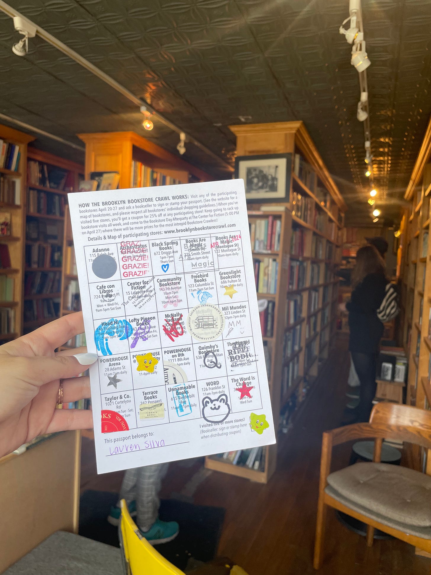 My completed Brooklyn Bookstore Crawl passport which looks like a bingo card filled with many stamps and stickers.