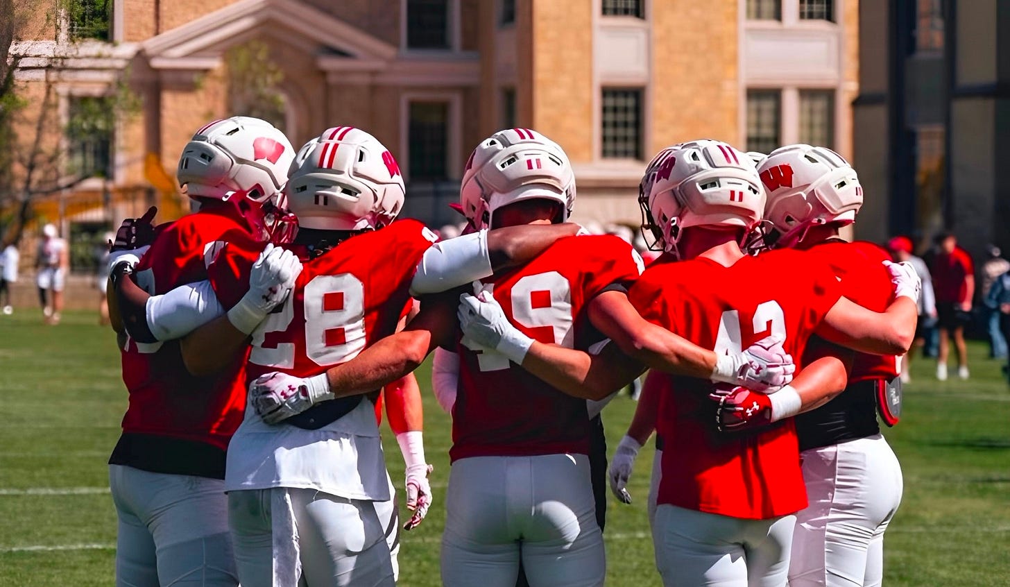 Wisconsin Badgers linebackers gather in a huddle during outdoor spring football practice. Photo credit: UW Athletics. Wisconsin Badgers linebackers gather in a huddle during outdoor spring football practice. Photo credit: UW Athletics.