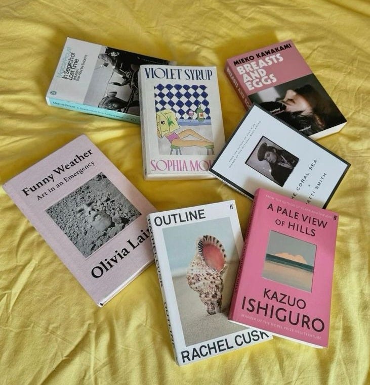This may contain: there are many books that are on the yellow bed sheetes and one is about to be read by someone