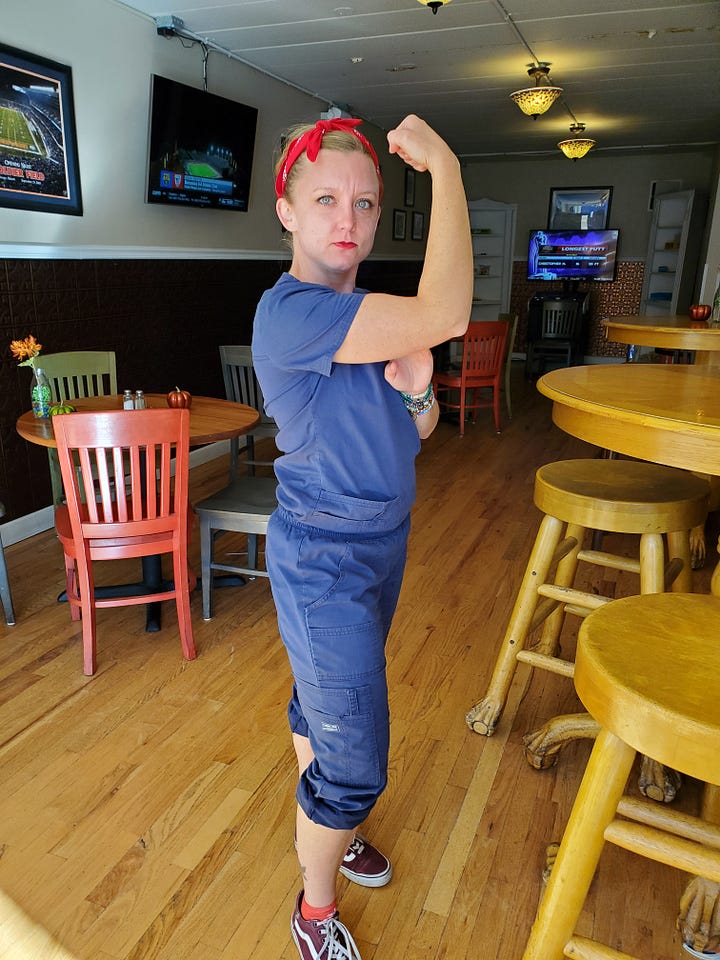 Woman wearing red bandana and scrubs to look like coveralls in a Rosie the Riveter pose. A beekeeper's market stand with a crowd dressed in costumes