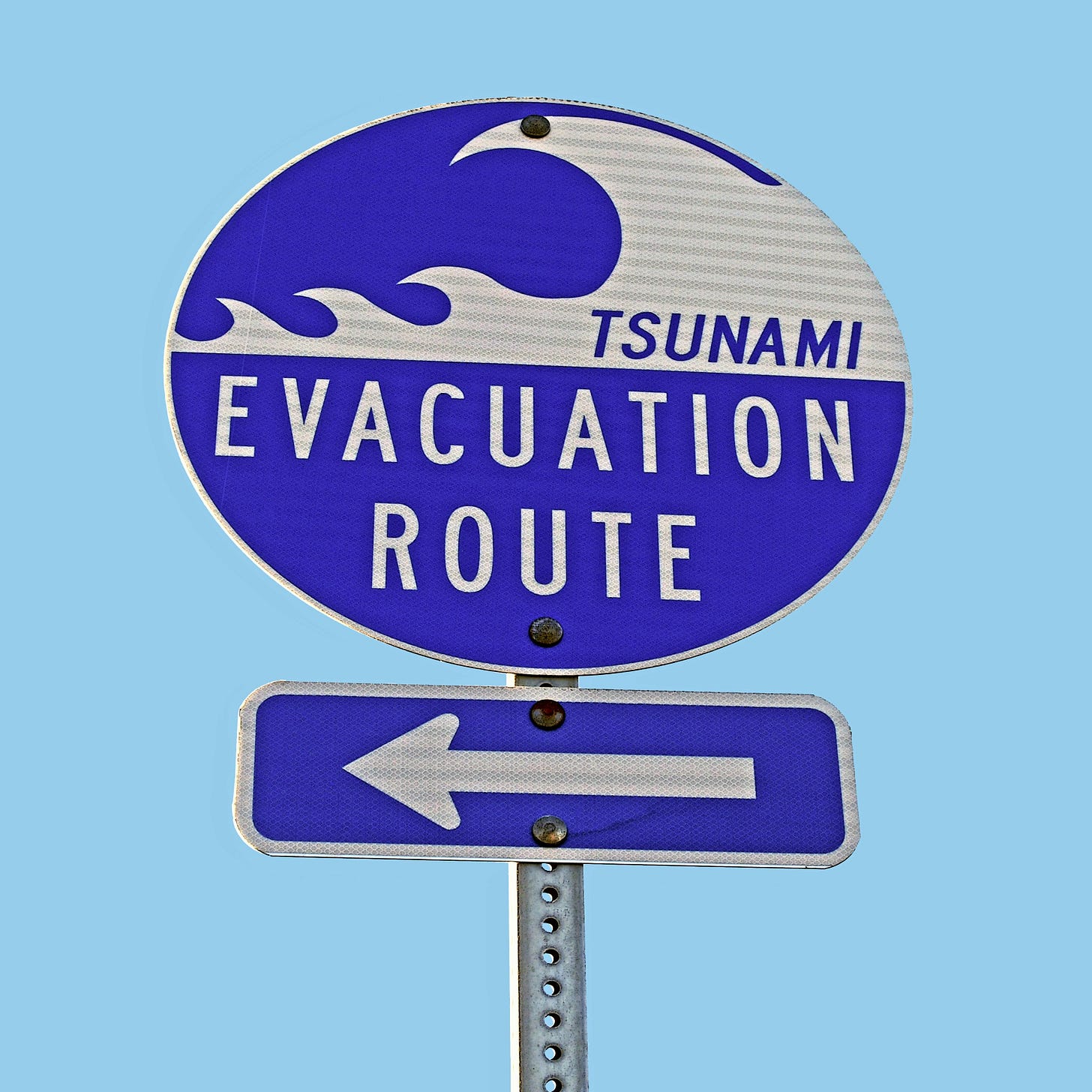 Tsunami warning sign pointing to evacuation route
