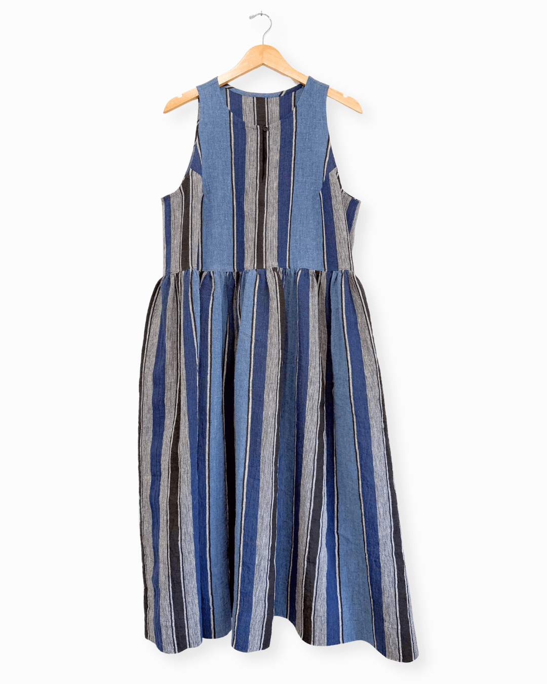 Blue and black striped linen Austin Dress View B without button bands hanging on wooden hanger showing gathered skirt and keyhole neckline