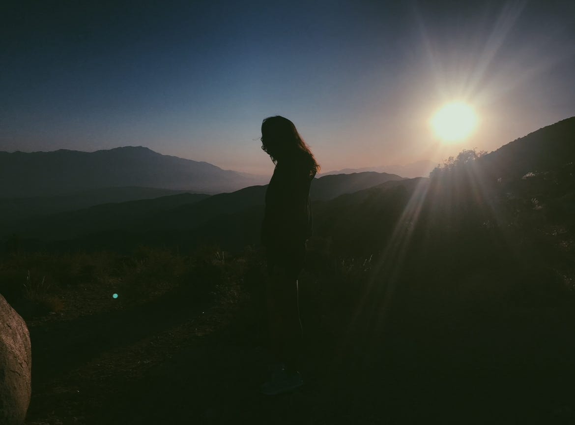 Picture shows a silhouette in front of a backdrop of mountain vistas.
