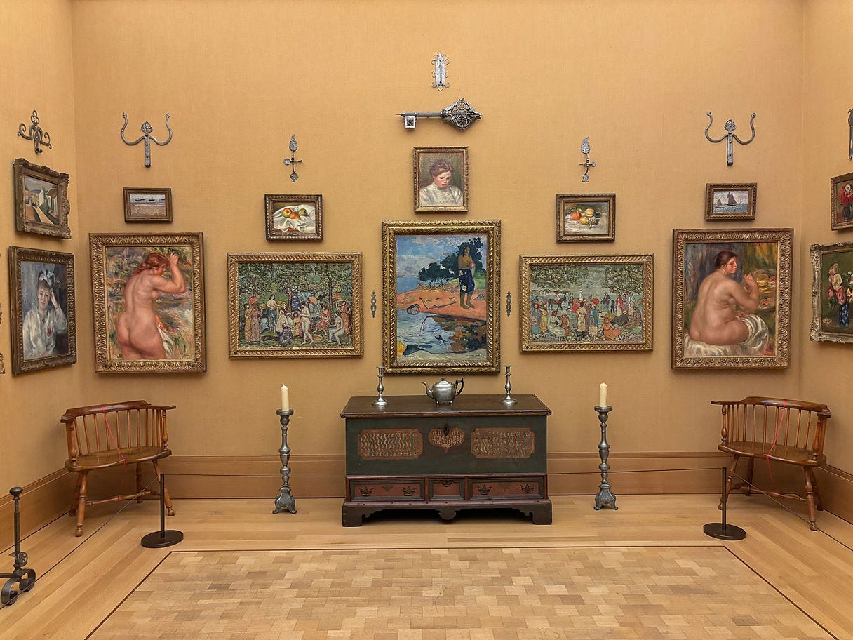 Gallery room with framed paintings on mustard walls, featuring figures and landscapes. Wooden chairs and ornate cabinet with candles. A museum worth visiting!