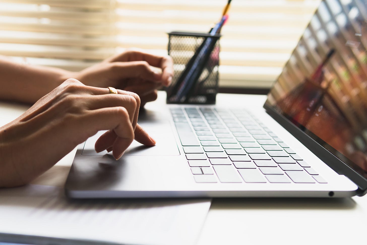 Close up of a woman's hands as she types on a laptop computer