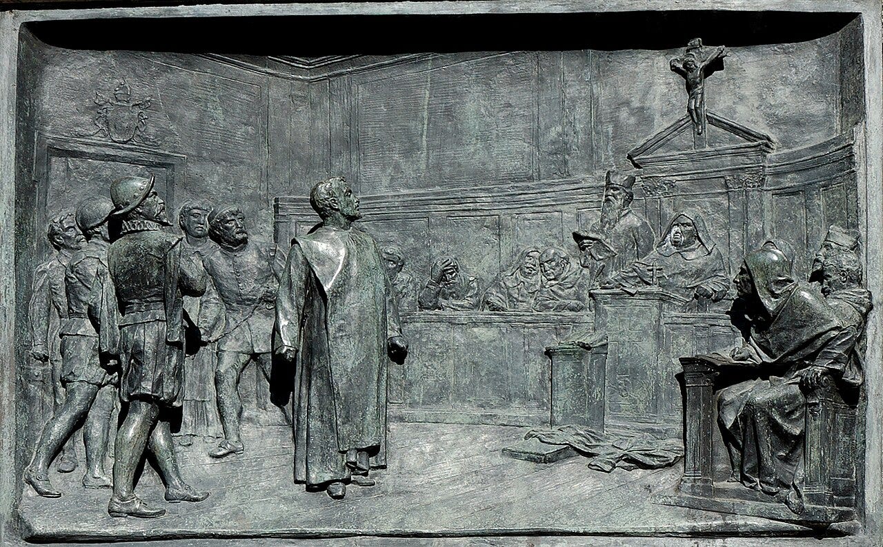Giordano Bruno vor dem Inquisitionsgericht — Bronzerelief von Ettore Ferrari am Bruno-Denkmal auf dem Campo de’ Fiori, 1889. Foto: Jastrow, gemeinfrei, via Wikimedia Commons