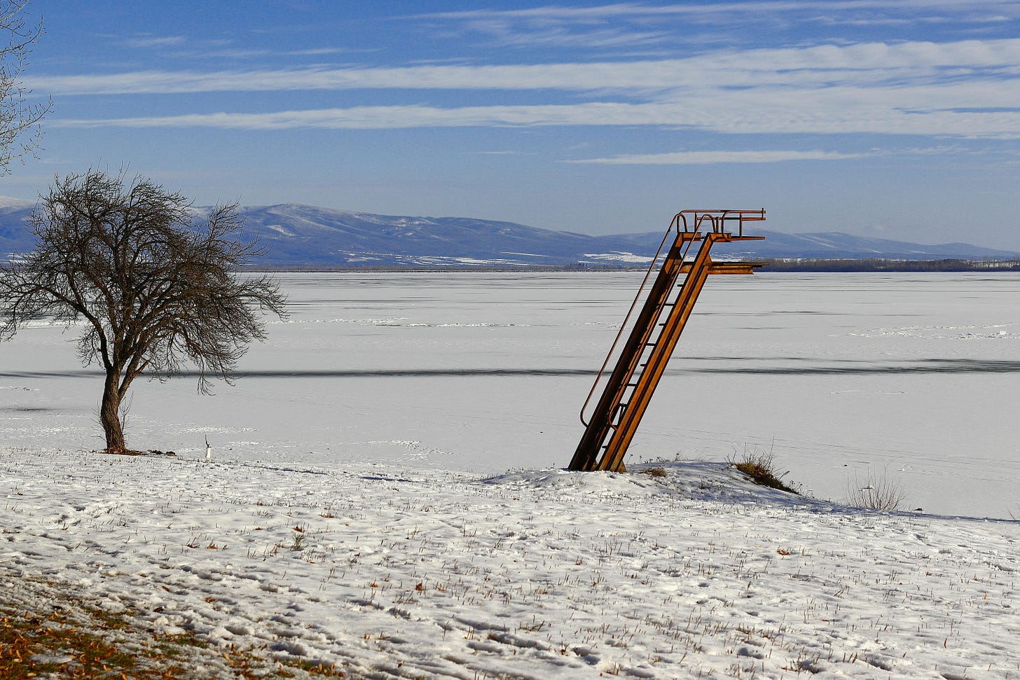 A broken ladder to nowhere in a snowy wasteland