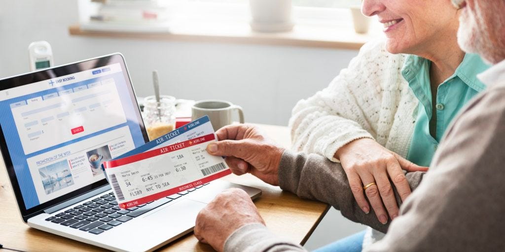 Senior Adult Holding Ticket Laptop Concept