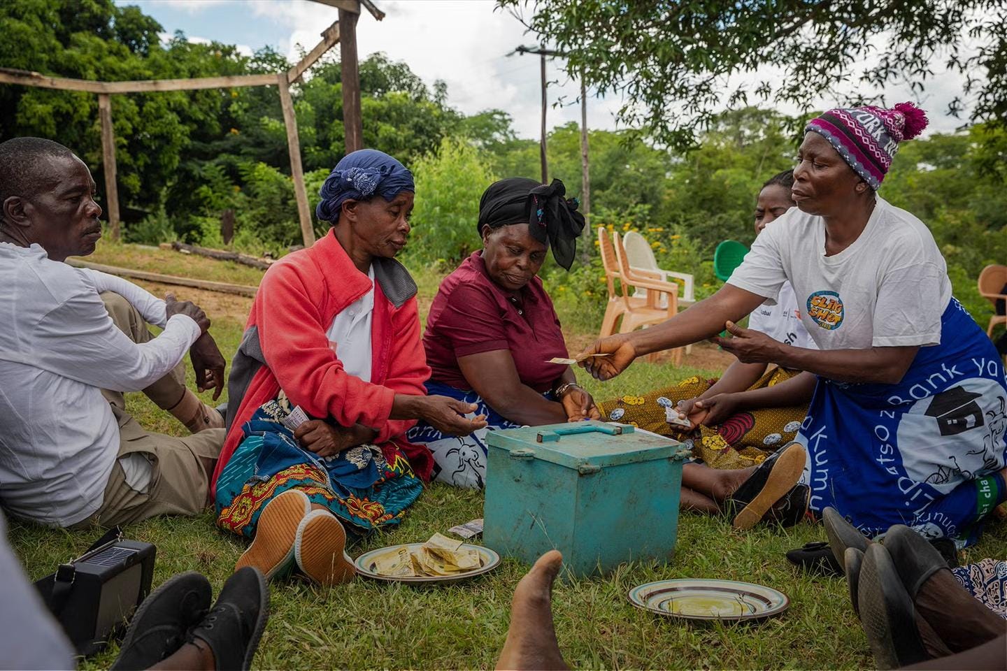 Image of group sitting and exchanging money