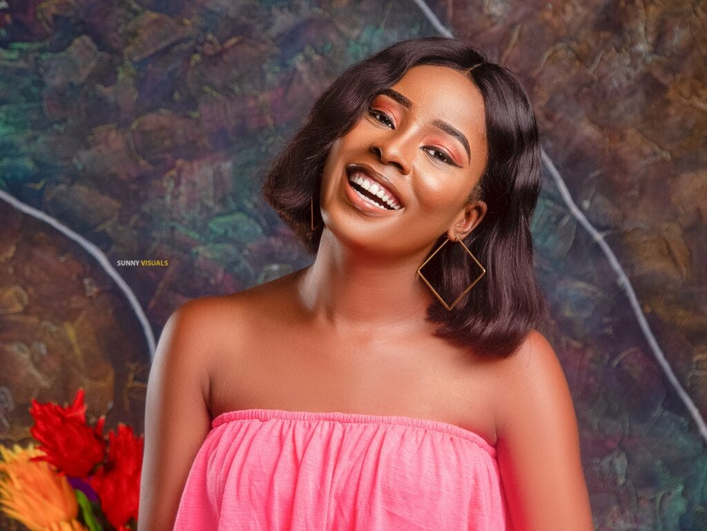 Ibi Fiberesima, a community manager, wearing a pink sleeveless dress and smiling to the camera