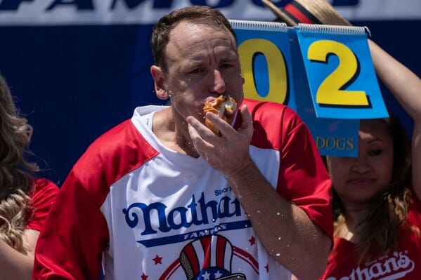 Joey Chestnut reclaims title in Nathan's Famous hot dog eating contest,  wins 17th Mustard Belt | AP News
