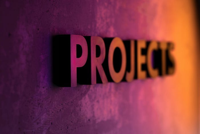 The Word “Projects” in metallic, raised letters, in a purple and yellow light.