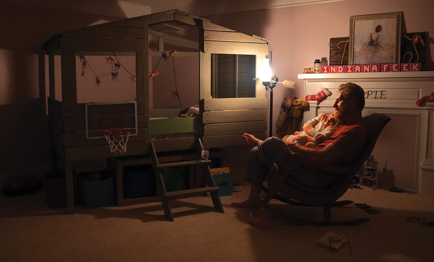 Rory sitting with Indy on a rocking chair in Indy's room
