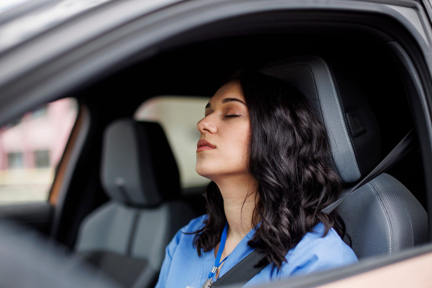 Sleepy medical worker resting in car. Sleepy medical worker resting in car.