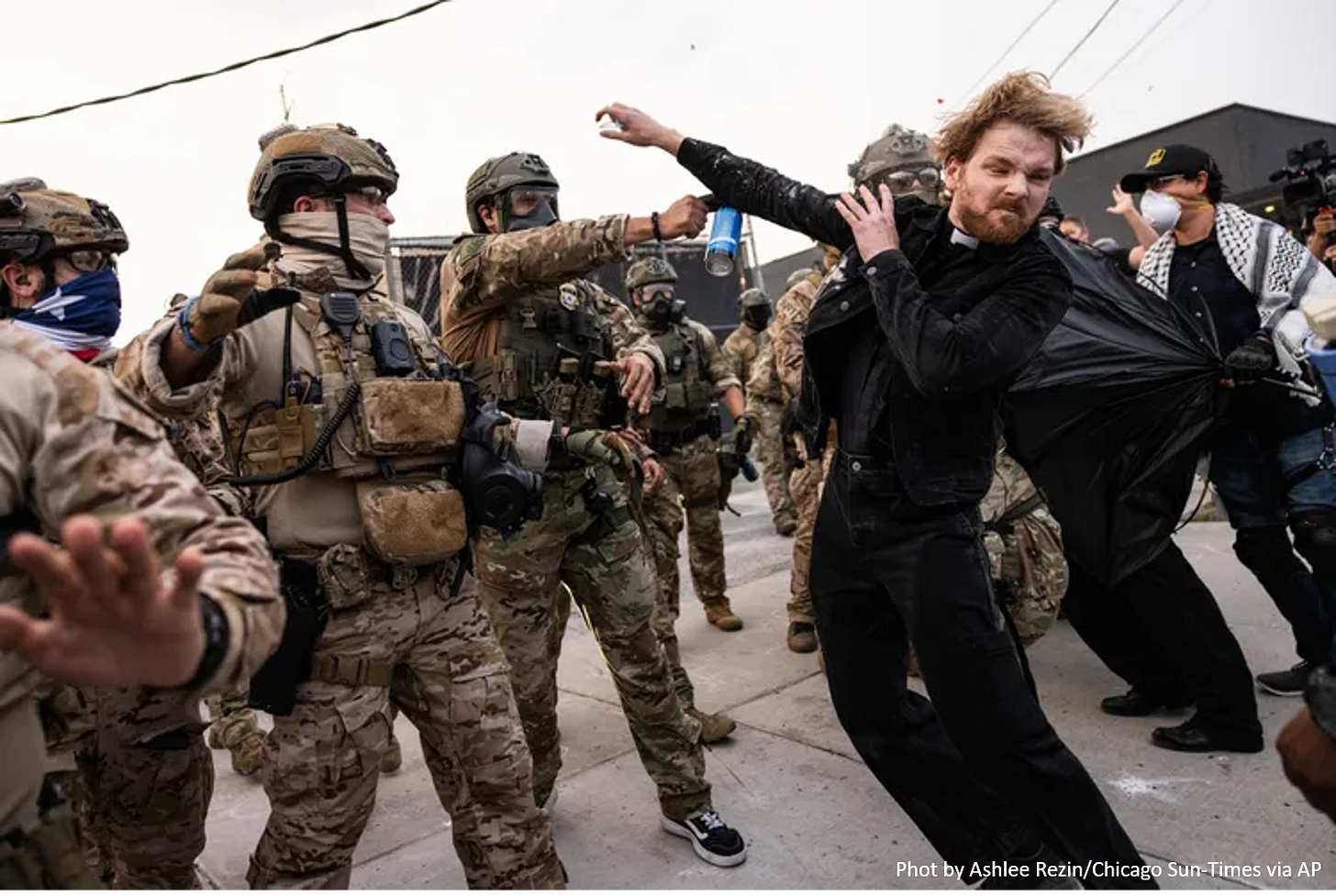 Photograph of the Reverend David Black being struck by a pepper ball fired by ICE agents at a protest in Chicago. Photo by Ashlee Rezin of the Chicago Sun-Times via the Associated Press.