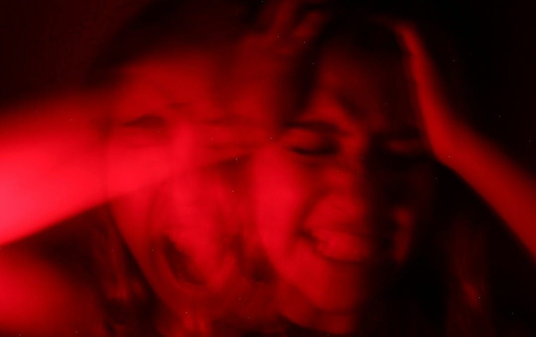 a woman is smiling while holding her hands up