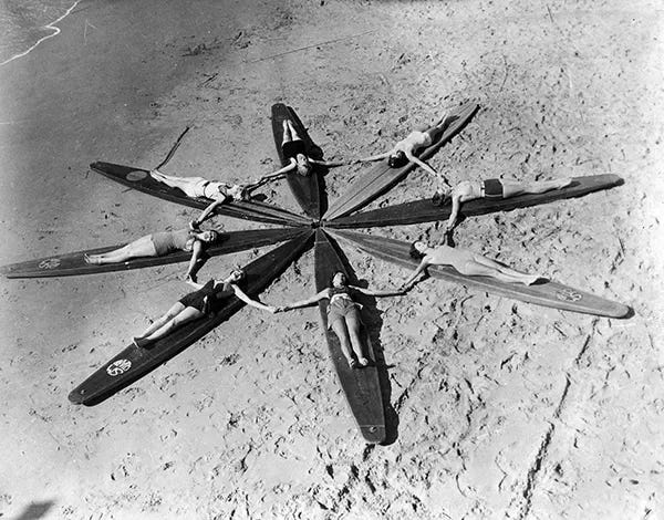 Women surfboarders forming a star formation on their huge hollow boards at Santa Monica Beach, circa 1935. Women surfboarders forming a star formation on their huge hollow boards at Santa Monica Beach, circa 1935.