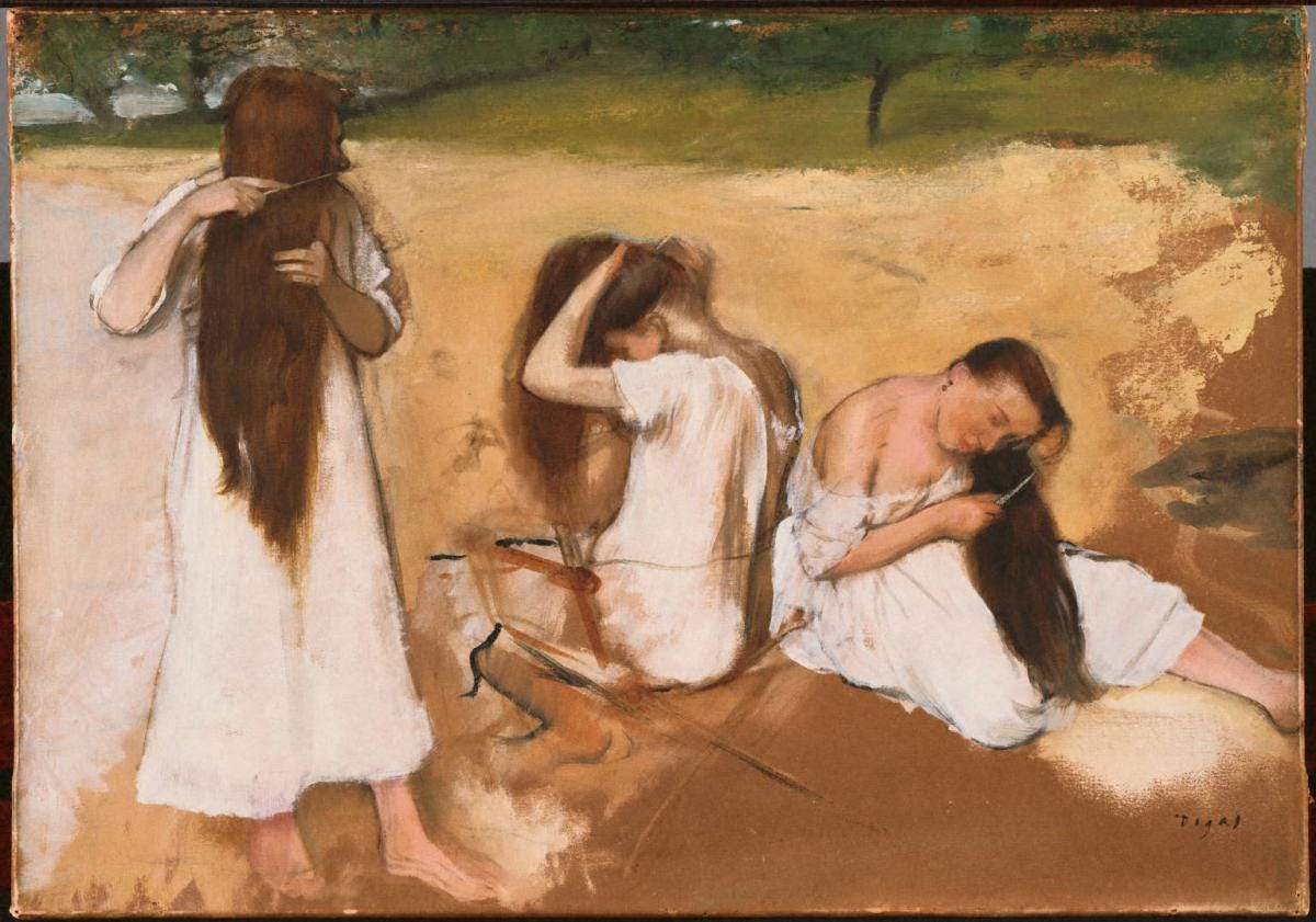 Three young women in different positions outdoors, combing their own hair. All three of them are wearing long flowy white dresses. On the left, the woman is standing with some of her profile concealed by her hair as she combs it. In the centre, the woman is turned away, seated on a chair, her arms raised as she combs her hair. On the right, the woman is seated on the ground, face visible, combing her hair on the side. The sleeve of her dress has fallen so her shoulder is exposed.