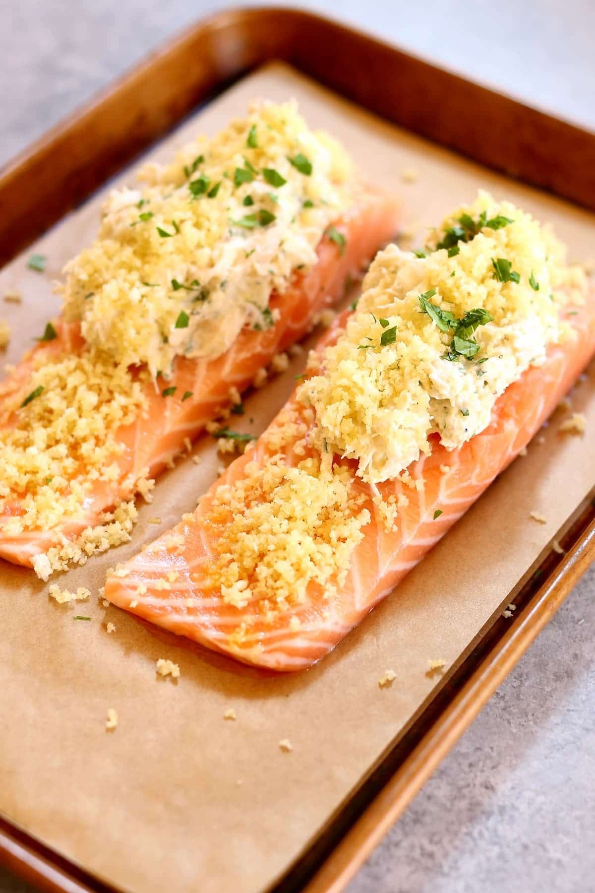two raw pieces of salmon on a baking sheet.