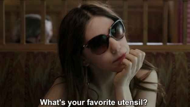This may contain: a woman wearing sunglasses sitting down with her hand on her face and the words what's your favorite utensil?