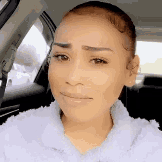 a woman is sitting in the back seat of a car with her eyes closed . a woman is sitting in the back seat of a car with her eyes closed .