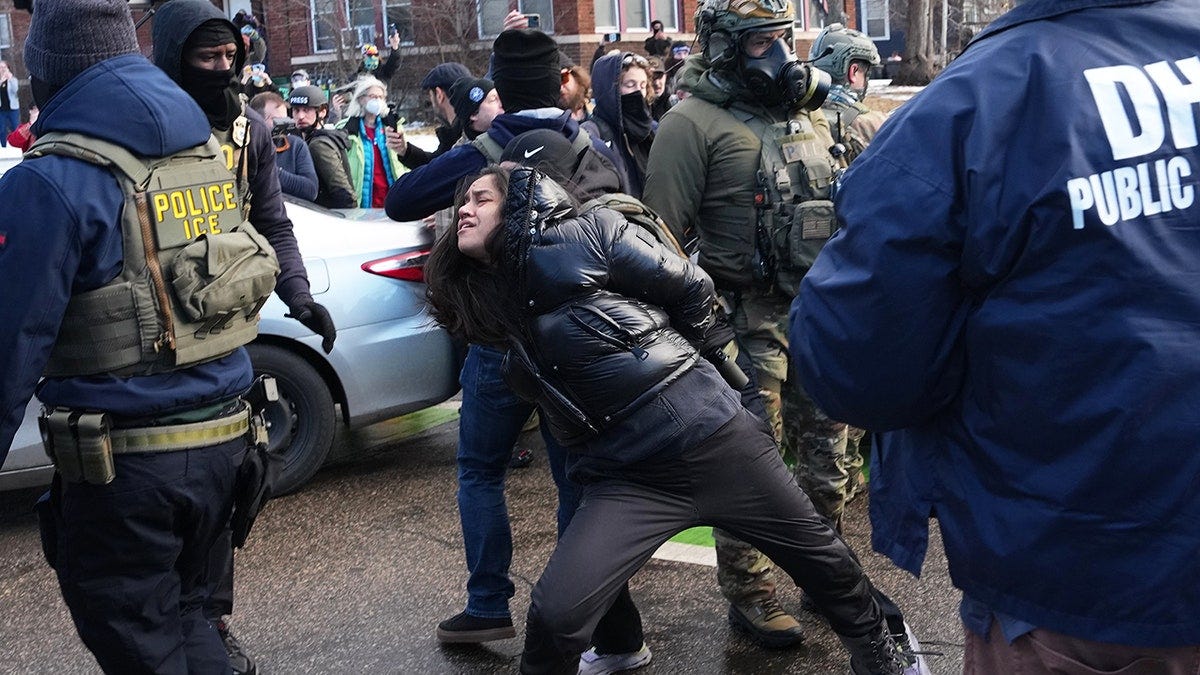 Federal agents detain demonstrator, who has hands behind her back, in Minneapolis