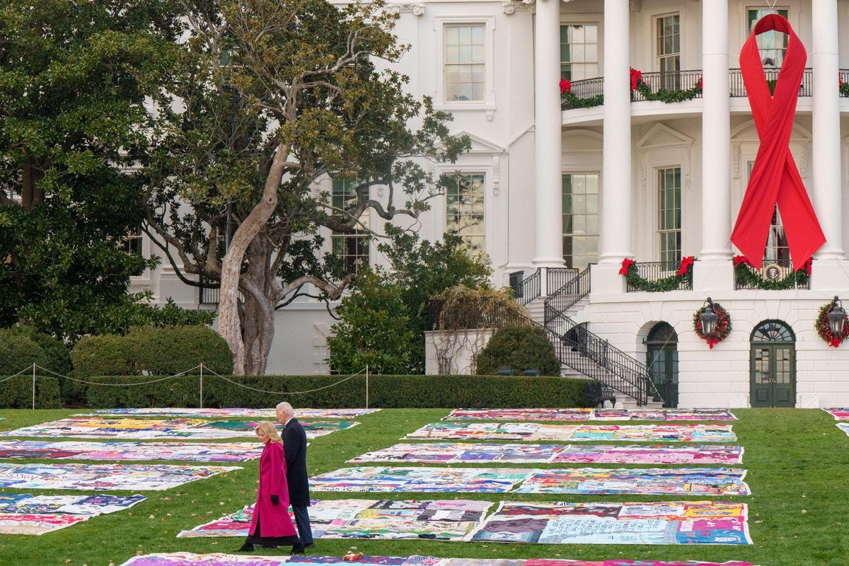 President Biden and the First Lady walk past the AIDS Memorial Quilt on the White House South Lawn. President Biden and the First Lady walk past the AIDS Memorial Quilt on the White House South Lawn.
