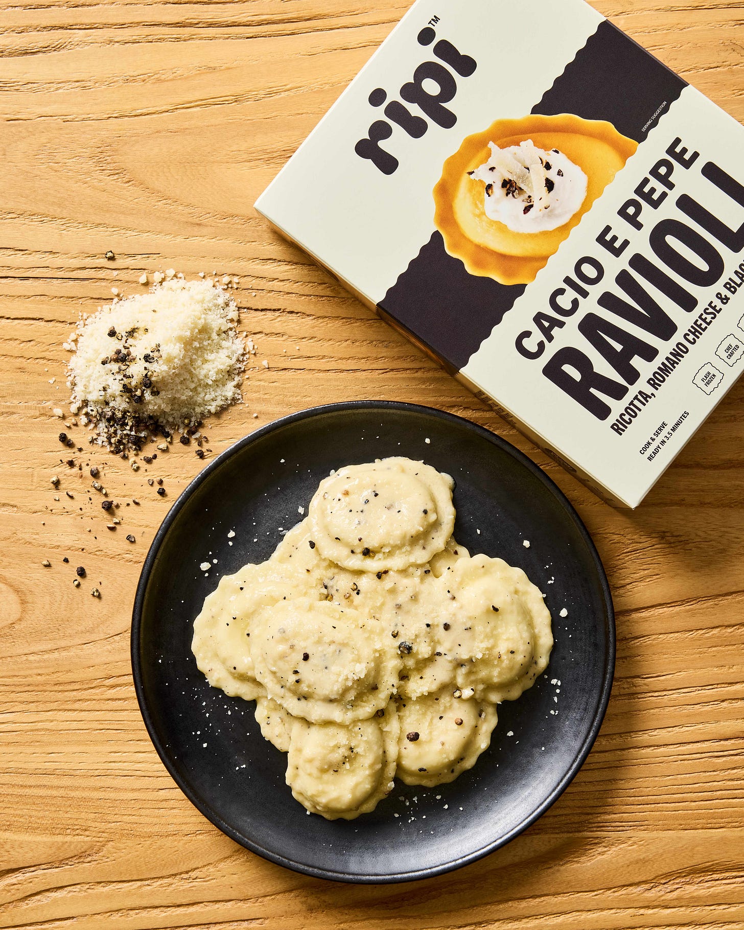 Ripi cacio e pepe ravioli on a black plate