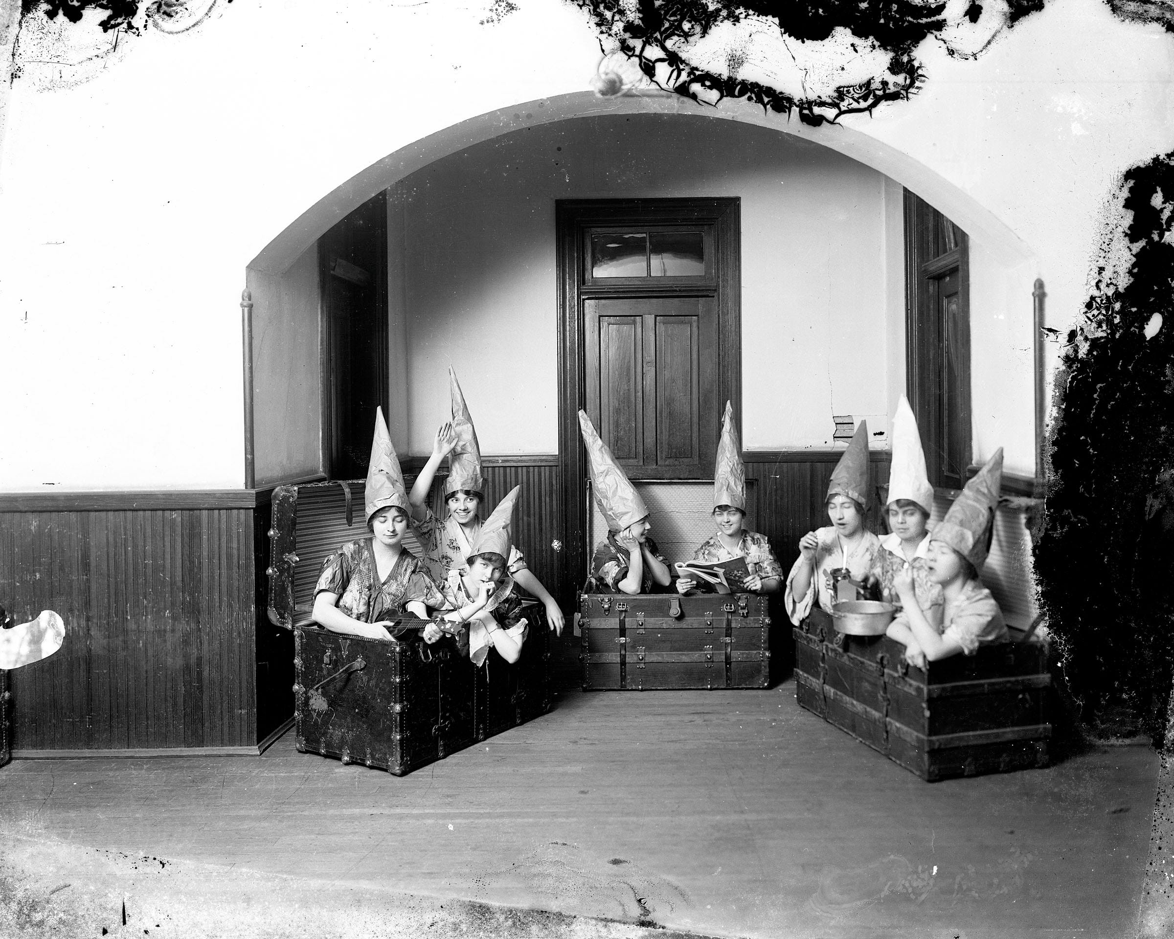women in trunks wearing pointy hats