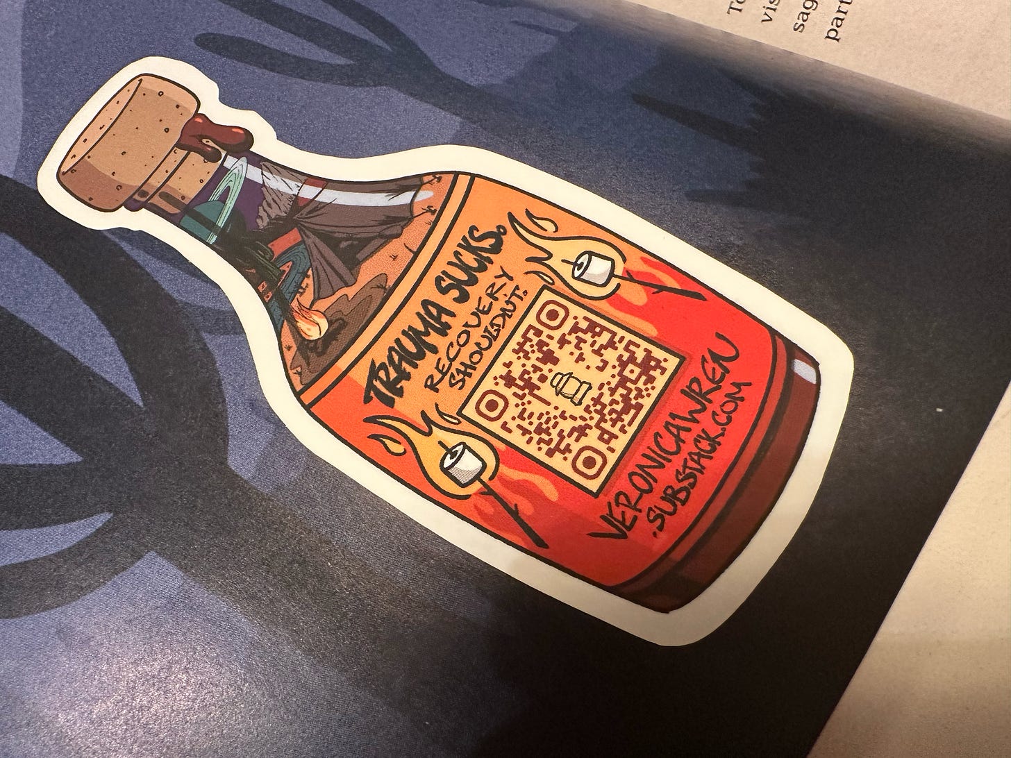 Sticker showing hot sauce bottle graphic. Bottle label has a QR code and says Trama Suck. Recovery Shouldn't. veronicawren.substack.com