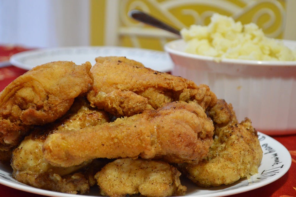 Plate of fried chicken with a dish of mashed potatoes