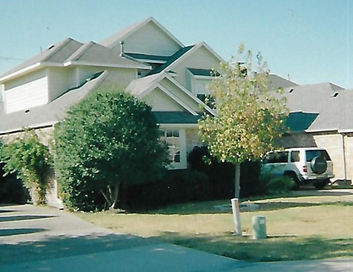 large suburban home with SUV in driveway