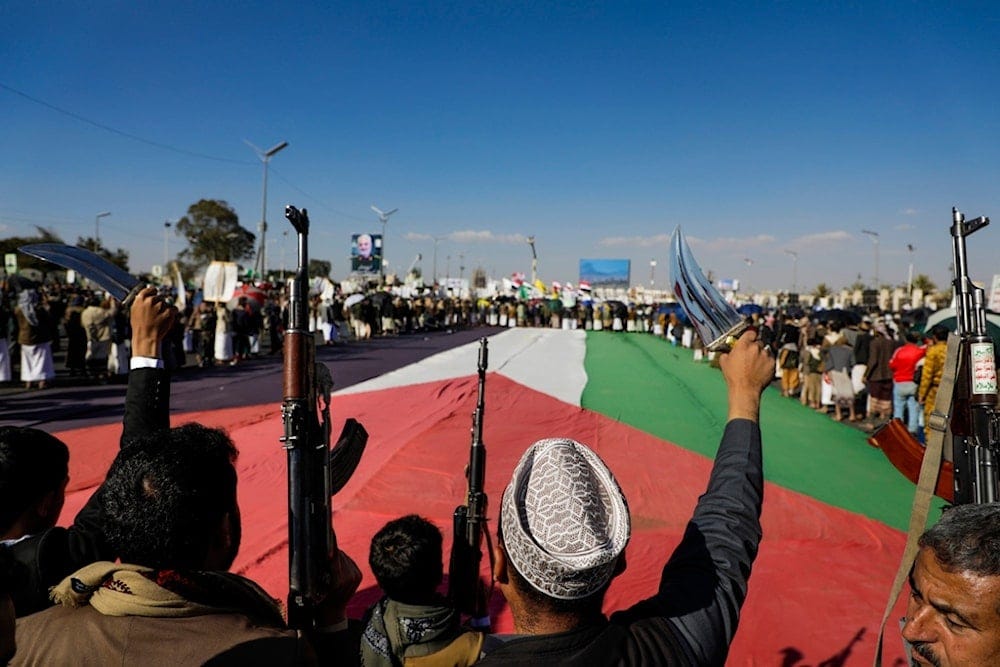 People gather around a giant Palestinian flag during an anti-Israeli rally in Sanaa, Yemen, Friday, Jan. 10, 2025 (AP) People gather around a giant Palestinian flag during an anti-Israeli rally in Sanaa, Yemen, Friday, Jan. 10, 2025 (AP)
