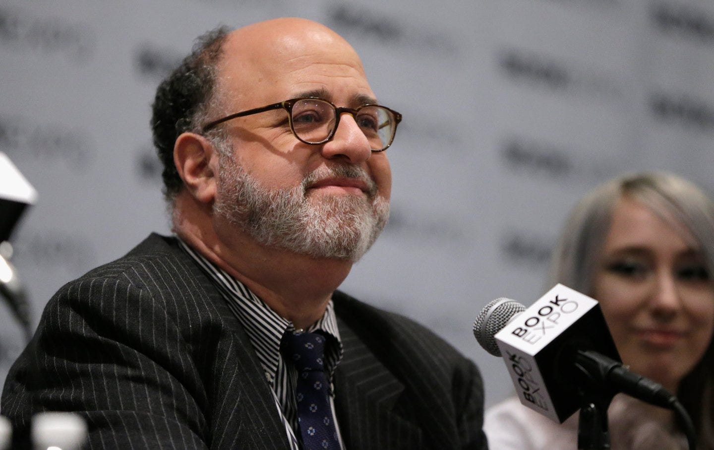 Commentary editor John Podhoretz sits in front of a microphone with “Book Expo” written on it. Commentary editor John Podhoretz sits in front of a microphone with “Book Expo” written on it.