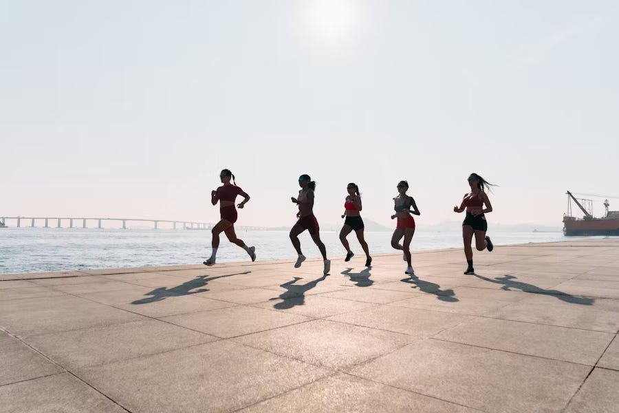 five women running on waterfront