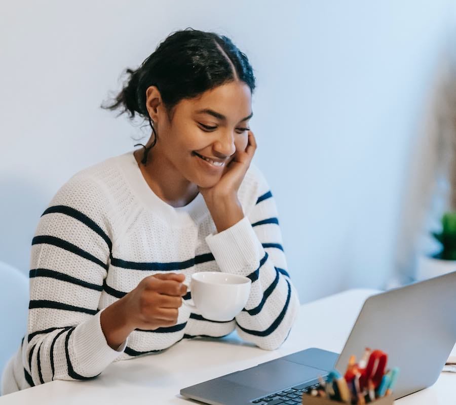 Young lady smiling at her laptop screen Young lady smiling at her laptop screen