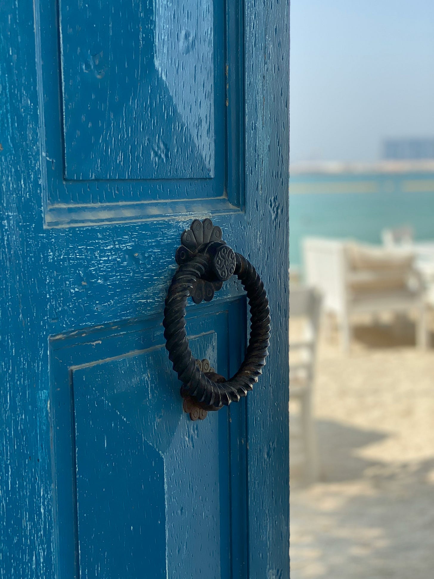 Una porta blu che si apre su una spiaggia