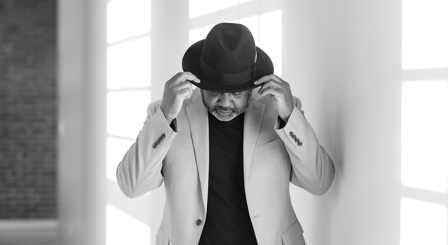 Clayton Craddock adjusting the brim of his hat in a black-and-white portrait Clayton Craddock adjusting the brim of his hat in a black-and-white portrait