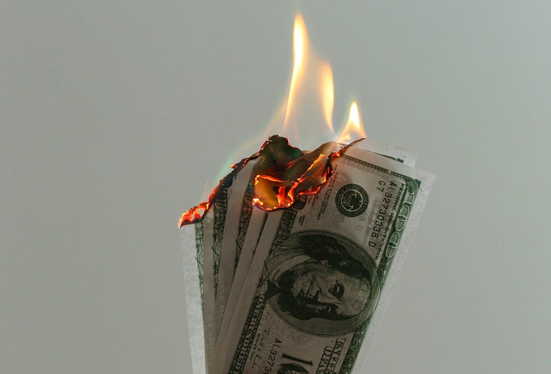 time lapse photography of several burning US dollar banknotes