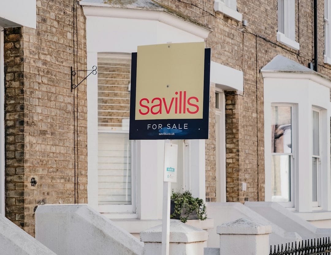 Savills for sale sign outside brick townhouses