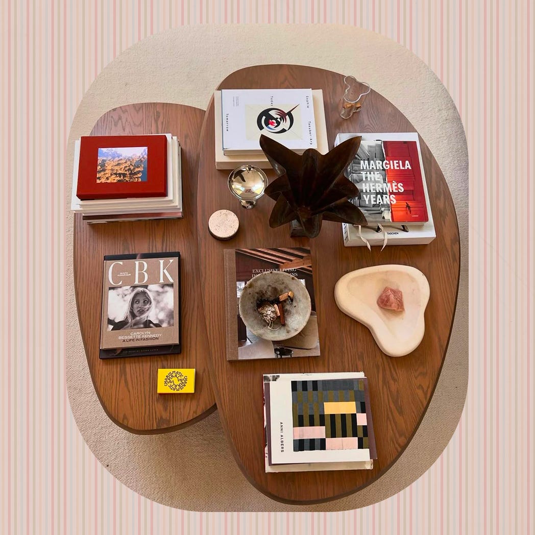 Top-down view of a curated coffee table with books, decor objects, and trinkets.