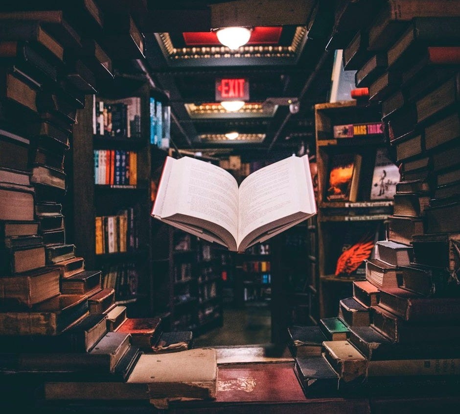 view of floating open book from stacked books in library view of floating open book from stacked books in library