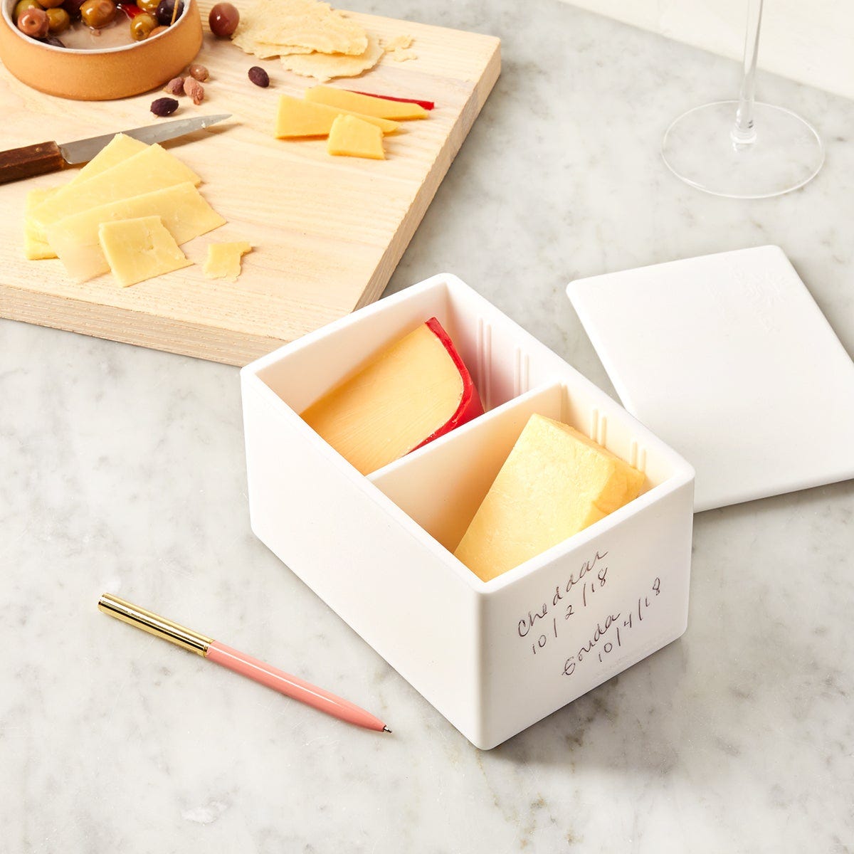 A cheese tray being prepared. Two types of cheeses are being held in a special cheese box.  A cheese tray being prepared. Two types of cheeses are being held in a special cheese box.