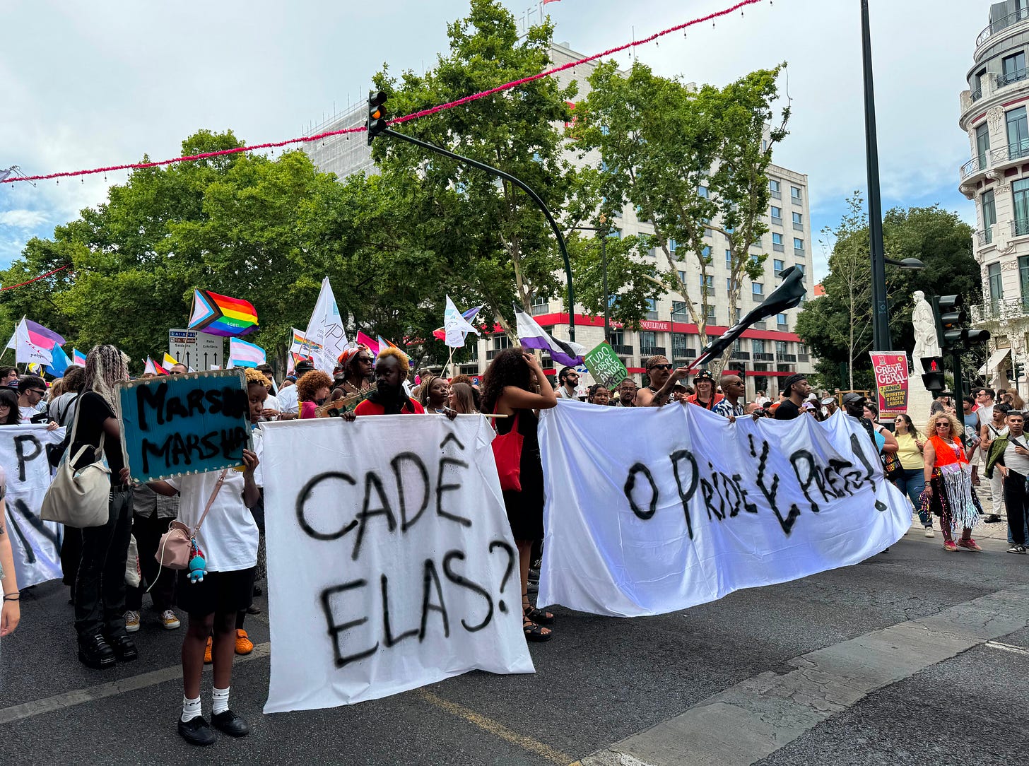 Marchers hold banners with spray-painted phrases. Marchers hold banners with spray-painted phrases.