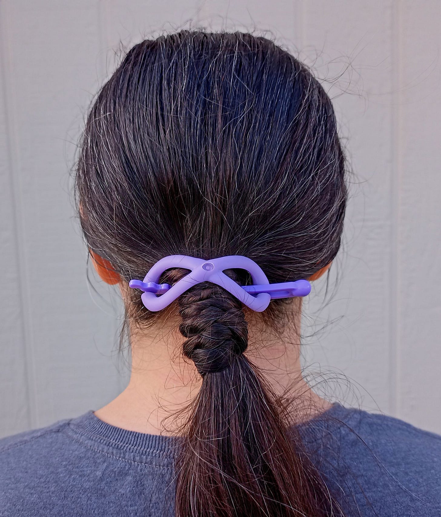 Woman with long brown hair with braided base ponytail in purple Flexi hair clip
