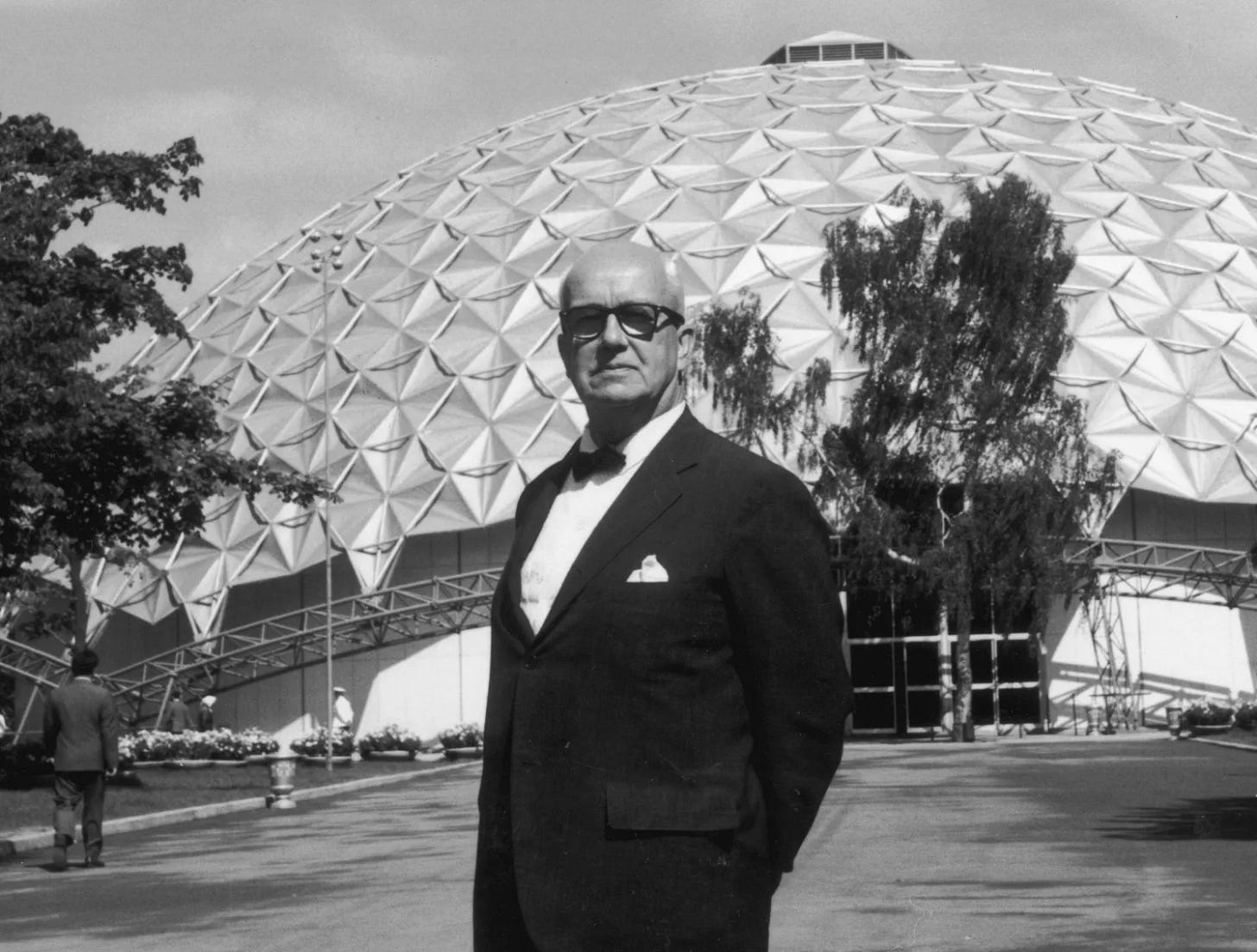 Richard Buckminster Fuller in front of a geodesic dome, the design of which he invented, c. 1960
