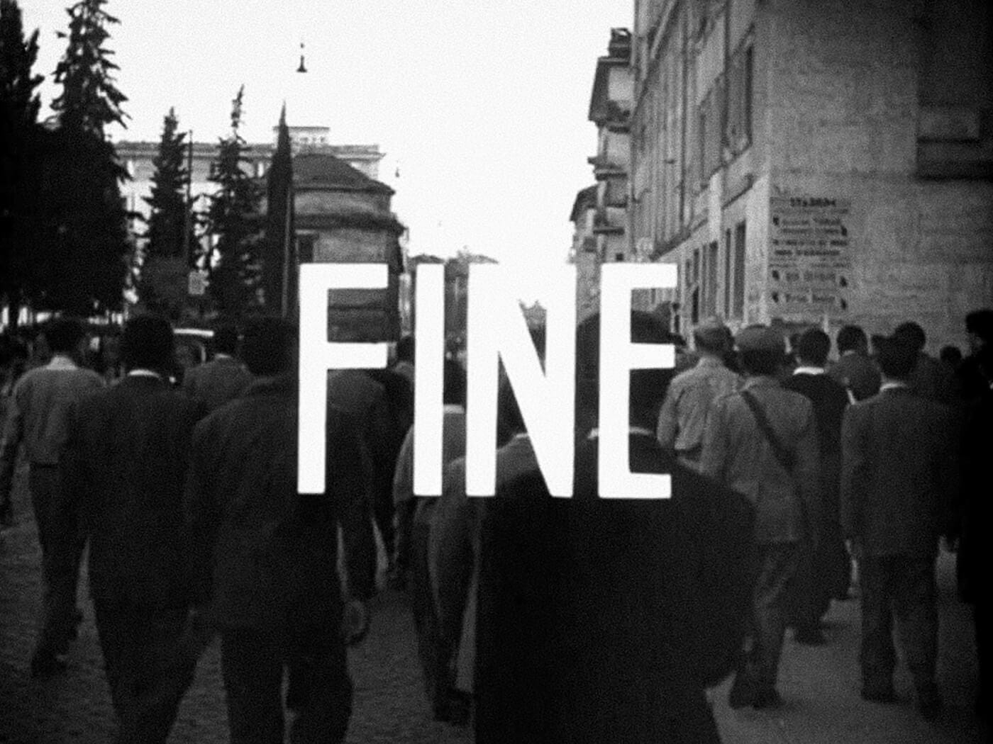 Final shot of Bicycle Thieves, showing a crowd walking away from the camera down a cobblestone street as the word “FINE” fades in with bold white type.
